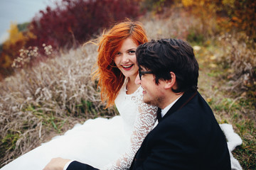 The lovely couple in love sitting on the seashore