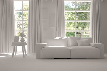 White room with sofa and green landscape in window. Scandinavian interior design