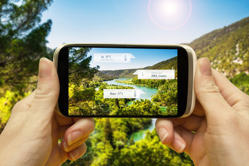Augmented reality applications for travel and leisure. Hand with a smartphone app A / R on-screen...