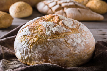 Several types of fresh bread lying on an old wooden table