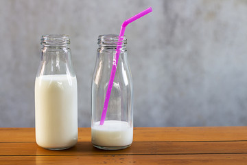 Milk in glass bottles on a wooden table.