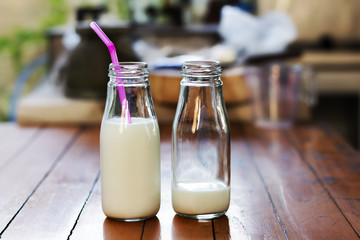 Milk in glass bottles on a wooden table.