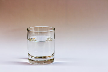 Clean drinking water is in the glass on a white table.