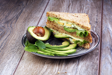 Sandwich with avocado and poached egg - healthy breakfast concept