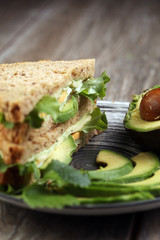 Sandwich with avocado and poached egg - healthy breakfast concep