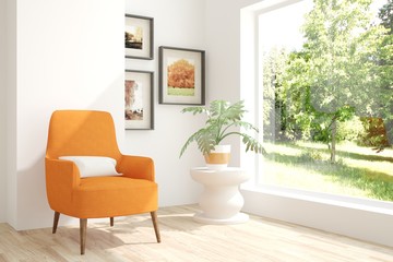 White room with armchair and green landscape in window. Scandinavian interior design