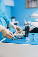 Detail of hand holding dental tools in dental clinic.