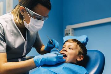 Fototapeta premium Dentists with a patient during a dental intervention to boy.