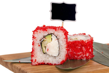 Sushi rolls on wooden Board with leaves of leeks and black sign for logo and name