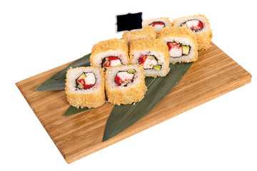 Sushi rolls on wooden Board with leaves of leeks and black sign for logo and name