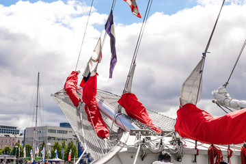 Bowsprit and gathered red sail of the sailing ship.