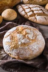 Several types of fresh bread lying on an old wooden table