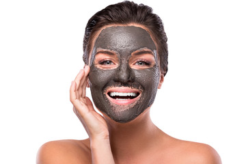 Beautiful woman with a clay or a mud mask on her face - obrazy, fototapety, plakaty