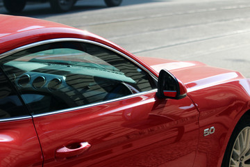 detail of red luxury car on the road