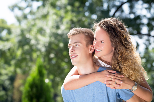 Young Couple Having Piggyback In A Park In Summer