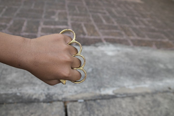 Hand man wearing brass knuckles