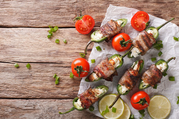 Baked Jalapeno pepper with feta cheese wrapped in bacon close-up. Horizontal top view