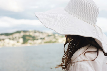 Romantic tones, woman with white hat and dress in the seaside