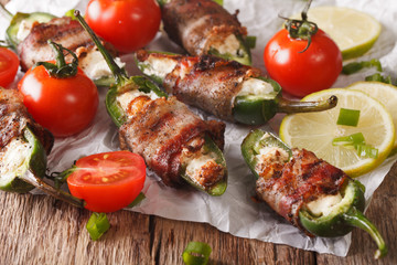 jalapeno peppers with feta cheese wrapped in bacon close-up. horizontal