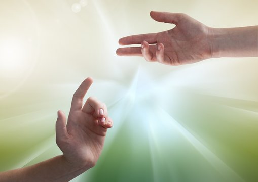 Composite image of Hands against illuminated green background