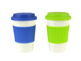 Two white porcelain containers for coffee or hot drinks with blue and green lids and thermo sleeves, isolated on white