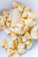 Chopped banana in white bowl macro closeup
