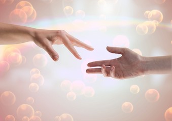Composite Image of two Hands against a shining background