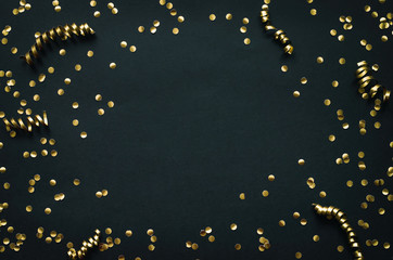 Golden confetti border frame on black paper background. Mardi Gras, New Year holiday decoration...