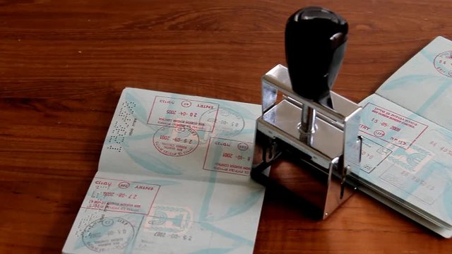 Passports and Stamp on Brown Wooden Desk