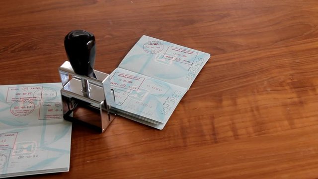 Passports and Stamp on Brown Wooden Desk