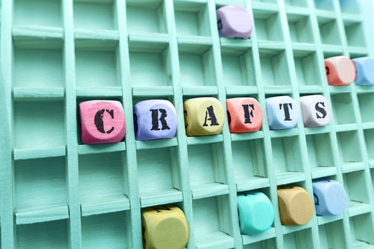 crafts word made with building wooden blocks / Composition of the word crafts with wooden cubes in square box