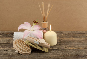 Beautiful composition with white candle and massage brushes on wooden background, weight loss and skin care concept