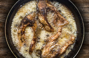 Fish in a frying pan. horizontal view from above. On the wood