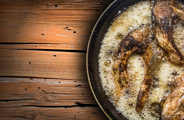 Fish in a frying pan. horizontal view from above. On the wood