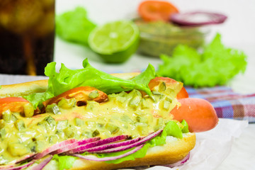 Homemade hot dog with some ingredients and glass of lemonade on the white background