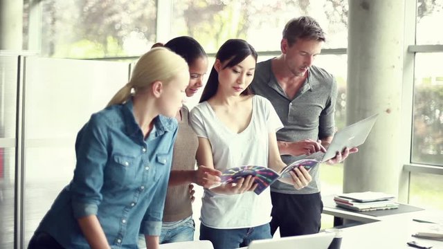 Office workers reviewing color swatch catalog together