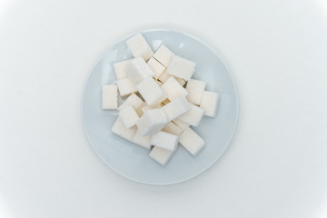 Fototapeta na wymiar light cubes of sugar on a plate