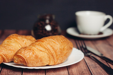 croissants on a saucer cutlery cup of coffee