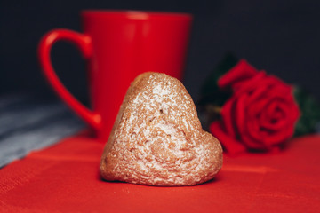 Red mug and flower on napkin, fruitcake with powdered sugar