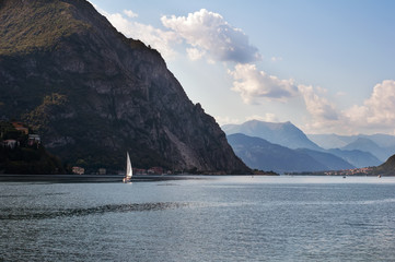 Il panorama sul lago tra le montagne con una barca a velo a Lecco, regione Lombardia, Italia 
