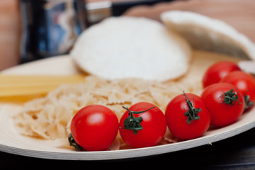 red tomatoes vermicelli and spaghetti on a wooden plate