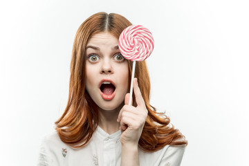surprised woman with open mouth and round lollipop