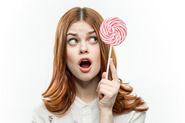 dumbfounded woman with open mouth looks at the lollipop