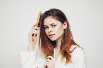 Fototapeta premium woman holding a wooden comb on her hair