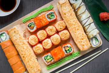 Japanese food. Sushi rolls and sauce with chopsticks on darg background. Top view. Flay lay