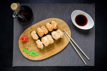 Japanese food restaurant, sushi roll set. Set with chopsticks, ginger, soy, wasabi. Sushi at rustic wood background. Flat lay, top view.