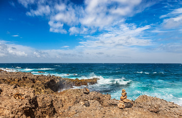 Rock piles perch on Aruba's windy, rocky north shore with rough seas even on a sunny Spring day