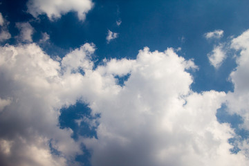 sun with sunbeams in a beautiful cloudy sky. blue sky is covered by white clouds