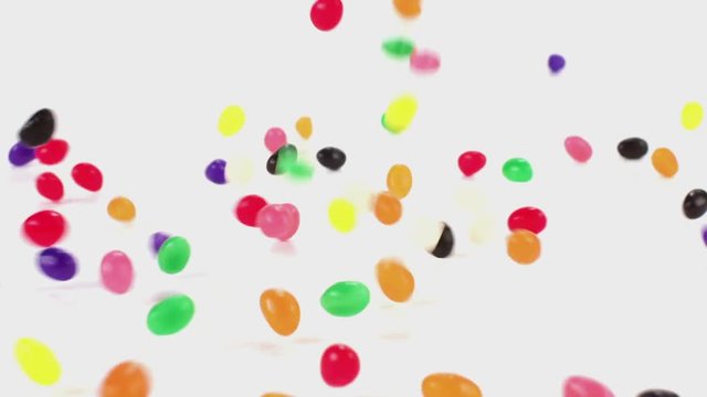 Jelly beans fall in slow motion onto a white cyc