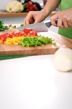 Close up of  woman's hands cooking in the kitchen. Housewife slicing ​​fresh salad. Vegetarian and healthily cooking concept